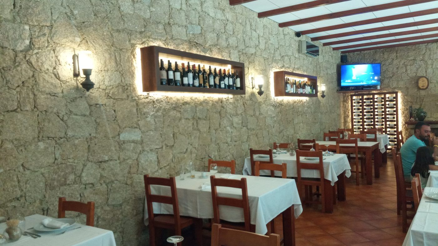 Sala com paredes de granito e nichos de vinho iluminados