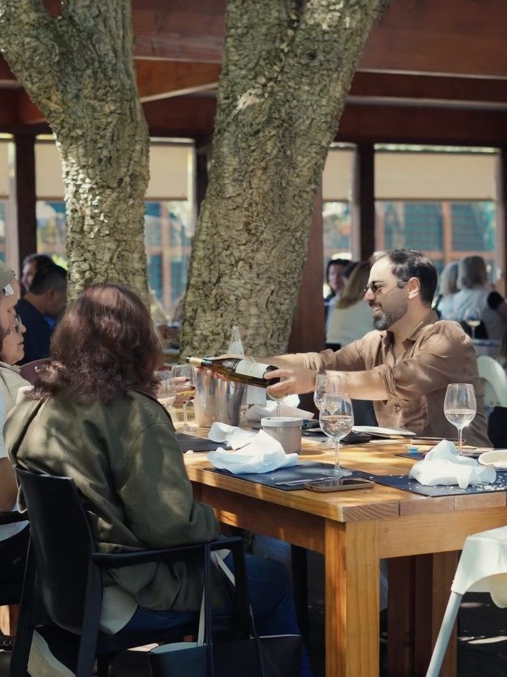 Vinho servido numa mesa da esplanada, entre duas árvores